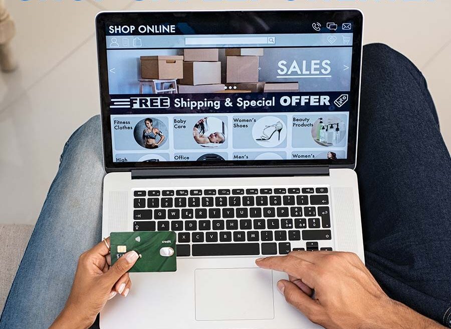 a couple is shopping online, they are sitting on a couch both using a computer. the camera is looking at the computer and keyboard, the wife is holding the credit card and the husband is navigating on the keyboard.
