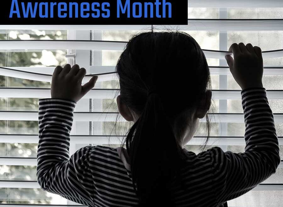 backlit picture of a child looking throgh a window with her hands on blinds, peering out.