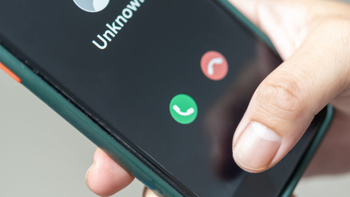 man holding mobile phone call from unkown number