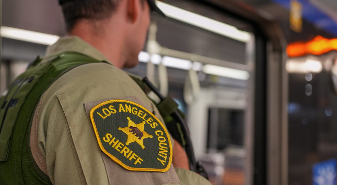 Picture of a Deputy on a train. The deputy's should is towards the camera and the patch is shown on his shoulder.