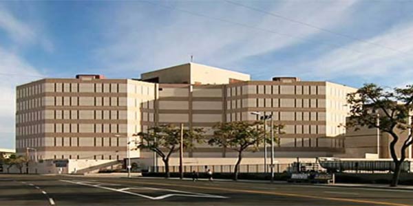 Twin tower Jail facility building seen from the street. Large Tan building